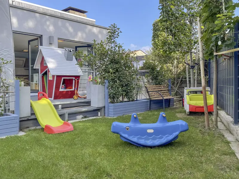 Garten einer mykidsplace-Kindertagespflege in Pulheim mit Spielhaus und Rutsche